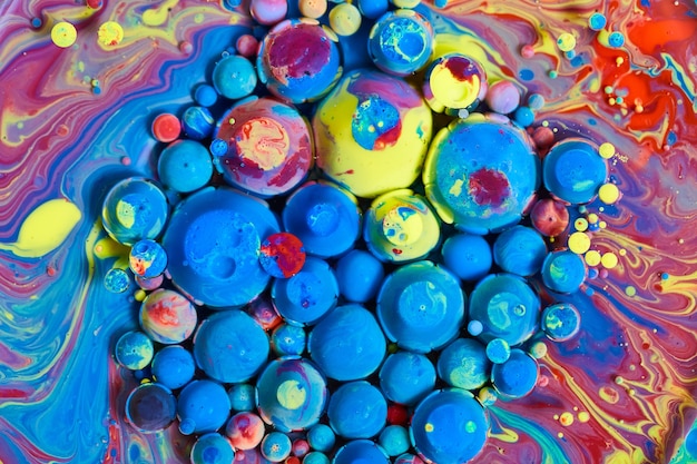 Afbeelding van een betoverende cluster van blauwe en regenboogbollen op een veelkleurig zijdeachtig oppervlak