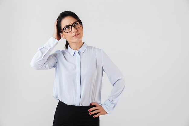 Afbeelding van een blanke zakenvrouw die een bril draagt ?? die zich in het kantoor bevindt, geïsoleerd over een witte muur