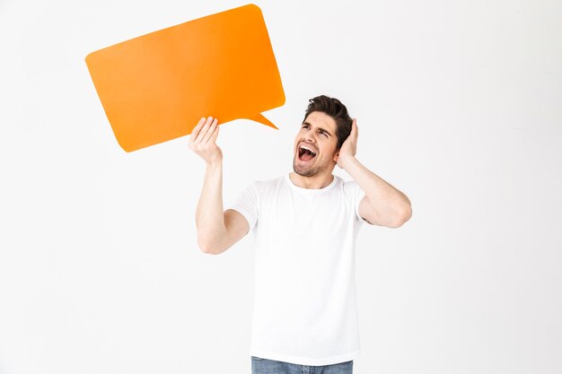 Afbeelding van een emotionele schreeuwende jongeman die zich voordeed over een witte muur met een tekstballon.