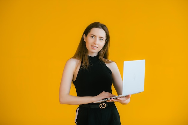 Afbeelding van een gelukkige optimistische emotionele jonge vrouw die een laptopcomputer gebruikt