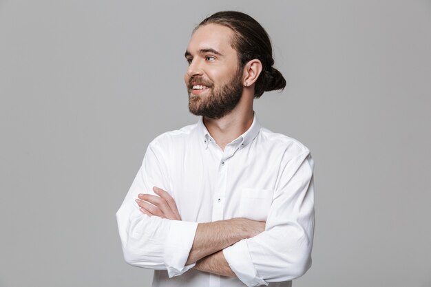 Afbeelding van een jonge lachende optimistische positieve knappe bebaarde man poseren geïsoleerd over grijze muur.