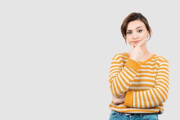 Afbeelding van een jonge vrouw die staat te denken