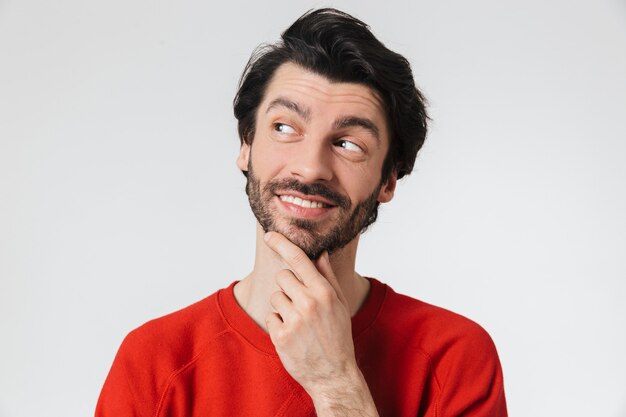 Afbeelding van een knappe jonge gelukkig man die zich voordeed op een witte muur.