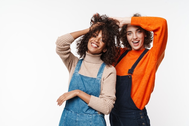 Afbeelding van een mooie, vrolijke, optimistische twee multiraciale meisjesvrienden in denim jumpsuits