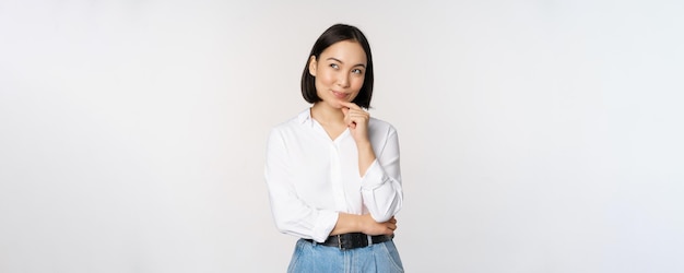 Afbeelding van een nadenkende glimlachende vrouw heeft een idee dat plannen maakt en opzij kijkt en denkt in een witte blouse op kantoor tegen de achtergrond van de studio