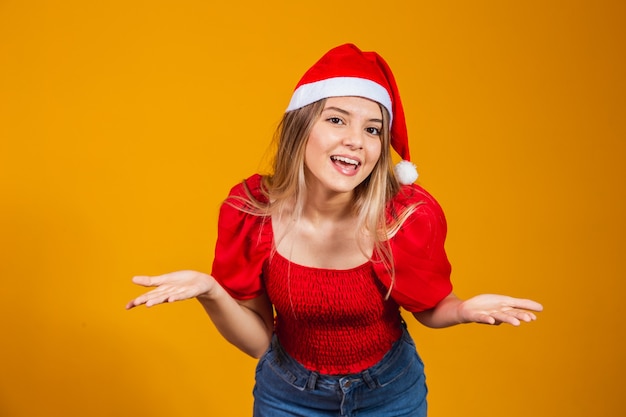 Afbeelding van een opgewonden schreeuwende jongeman die geïsoleerd staat over een gele achtergrond met een kerstmanhoed die naar de camera kijkt met kopieerruimte.