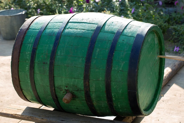 Afbeelding van een oud eiken wijnvat op de achtergrond van een landelijke binnenplaats