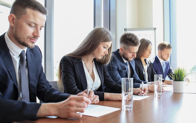 Afbeelding van een rij zakenmensen die op seminar werken