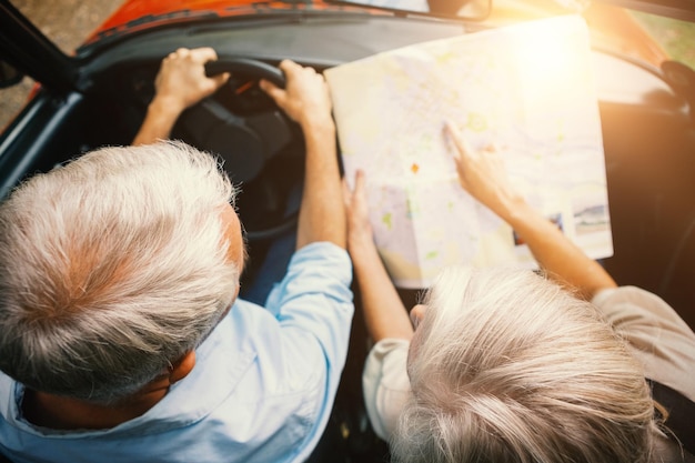 Foto afbeelding van een stel in een auto die naar een wegenkaart kijkt