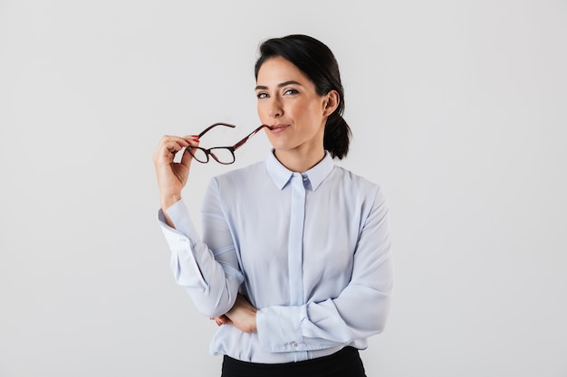 Afbeelding van een tevreden secretaresse vrouw die een bril draagt ?? die zich in het kantoor bevindt, geïsoleerd over een witte muur