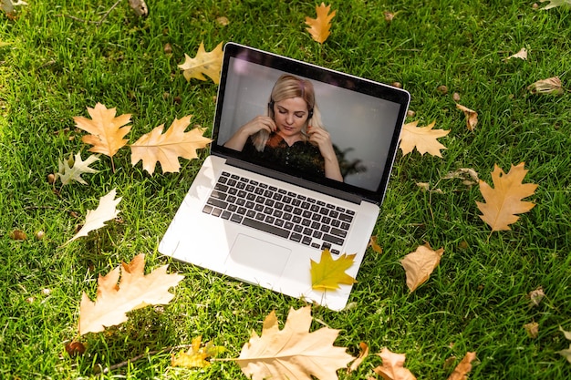 Afbeelding van herfstpark en videogesprek via laptop