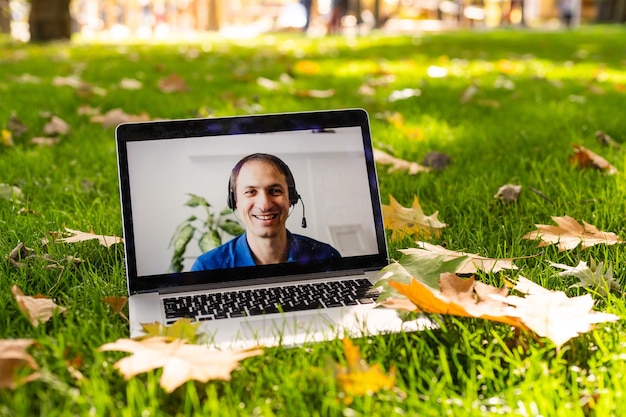 Afbeelding van herfstpark en videogesprek via laptop