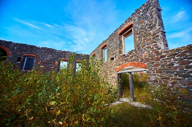 Afbeelding van het interieur van een verlaten gebouw zonder dak met de lucht volledig zichtbaar en ramen en deuren open voor elementen