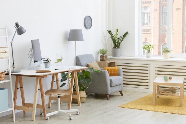 Afbeelding van huiskamer met werkplek met computer en fauteuil bij het huis