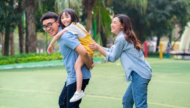 Afbeelding van jonge Aziatische familie die samen speelt in het park