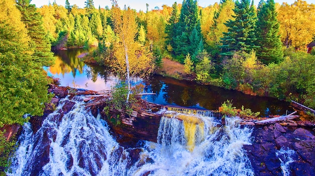 Afbeelding van luchtfoto van eagle river falls met natuurlijke rots- en boomdam en reflecterende rivier met herfstbomen en bladeren