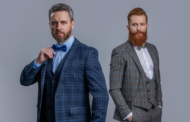 Afbeelding van mannen in smoking formalwear past bij mannen in smoking formalwear geïsoleerd op grijs