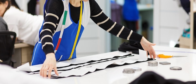 Afbeelding van ontwerper handen werken in werkplaats. vrouw bezig met het maken van nieuwe kledingcollectie.