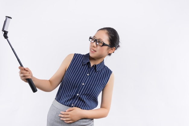 Afbeelding van schattige mooie jonge dame geïsoleerd op blauwe achtergrond Opzij kijken maken selfie via mobiele telefoon