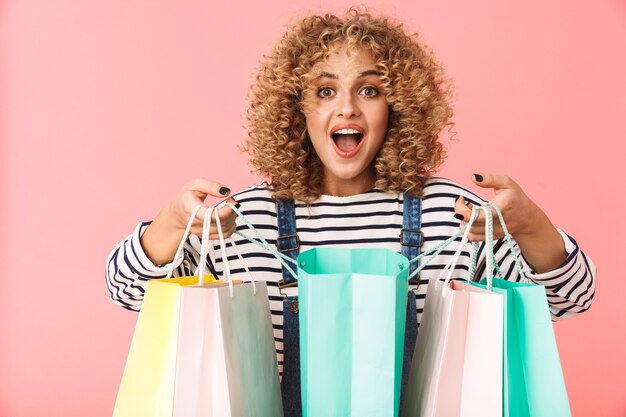 Afbeelding van vrij krullend vrouw 20s dragen casual kleding met kleurrijke boodschappentassen