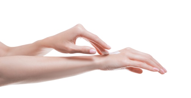 Afbeelding van vrouwelijke handen die crème op de huid aanbrengen. Medisch concept van gezonde huid- en handverzorging. Gemengde media