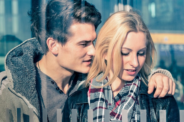 Photo affectionate couple of lovers behind glass reflections