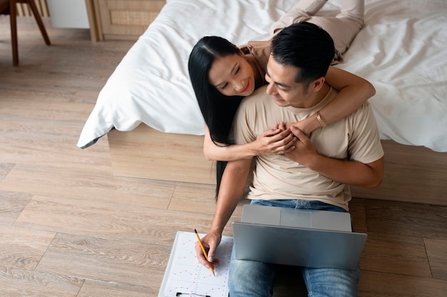 Photo affectionate couple working on laptop at home