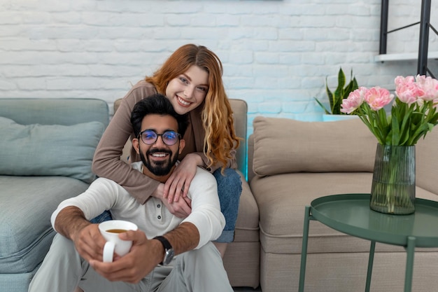 Photo affectionate loving married couple drinking coffeee enjoying spending time together at home relaxing sweet tender moment