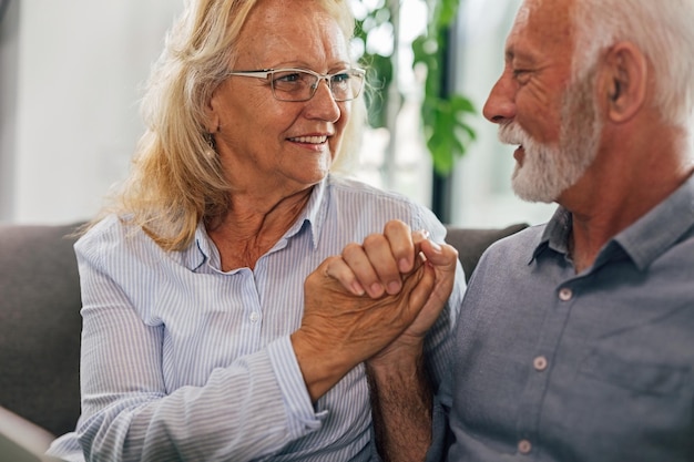 Affectionate mature couple communicating while holding hands and looking at each other Focus is on woman