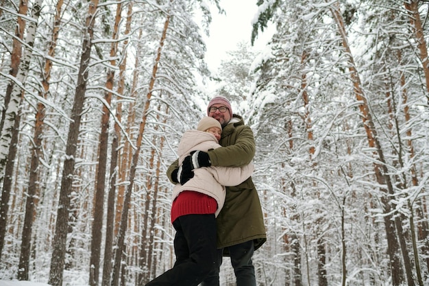 Affectionate mature couple in winterwear standing in embrace