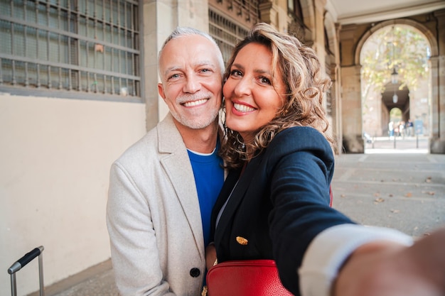 Affectionate mid adult married couple having fun taking a selfie portrait together on a romantic