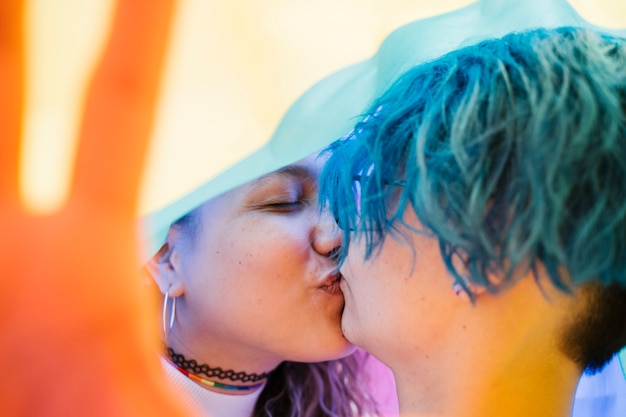 Affectionate moment between two women under a gay flag.