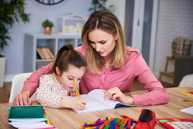 Mamma affettuosa che aiuta sua figlia con i compiti difficili