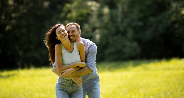 affectionate young couple having fun on the green grass at the park