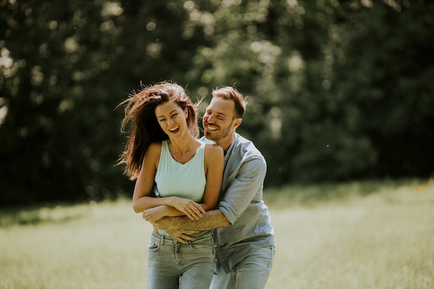 affectionate young couple having fun on the green grass at the park