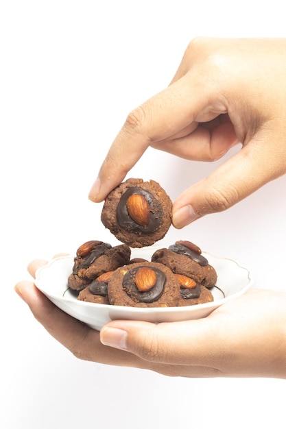 Afgaanse koekjes ophalen van chocolade en cornflakes met amandel bovenop in een kleine witte plaat geïsoleerd op een witte achtergrond