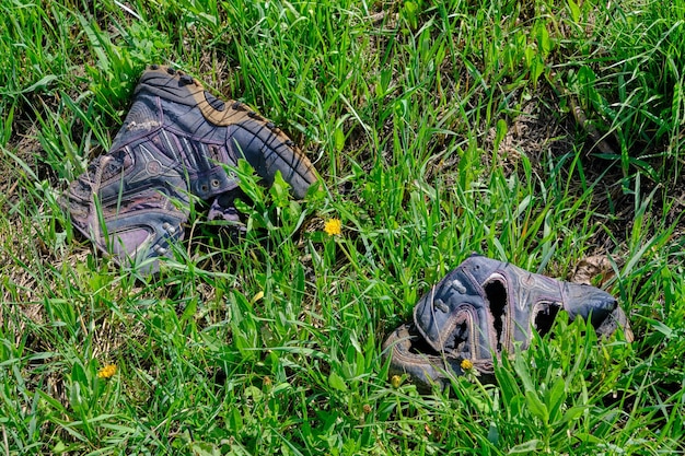 Afgedankte oude rotte schoenen vervuiling van ecologie en natuur