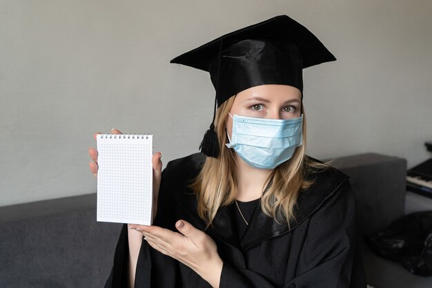 afgestudeerd medisch masker covid-19 master degree zwarte afstudeerjurk pet. afstuderen aan de universiteit.