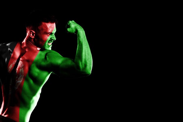 Afghanistan flag on handsome young muscular man, black background