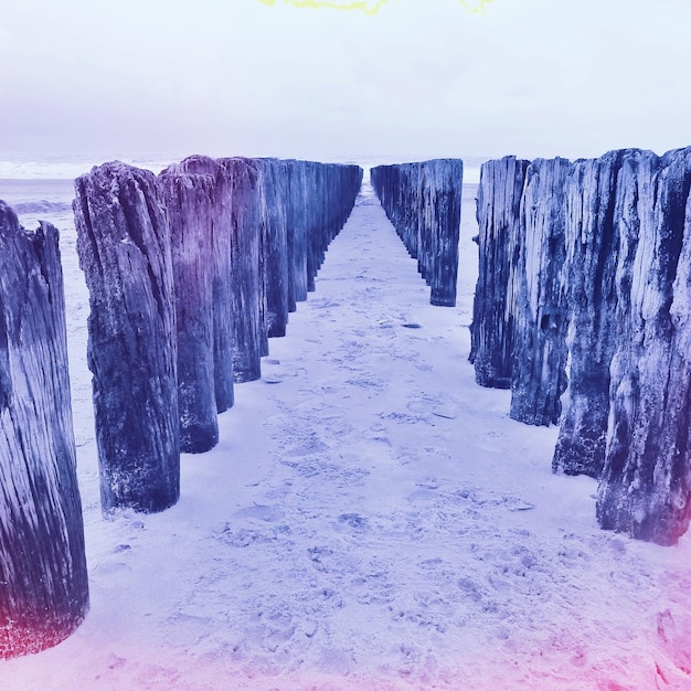 Foto afnemend zicht op houten palen op het strand