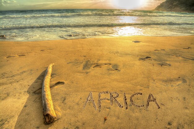 日没時に熱帯のビーチに書かれたアフリカ