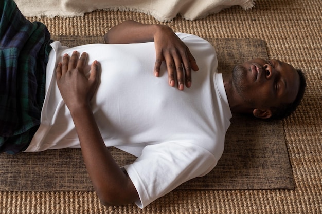 Photo african adult man relax after working out breathing man is tired after fitness workout laying on floor at home