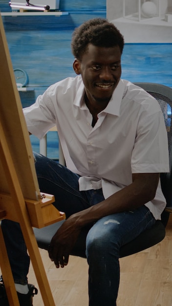 African american adult sitting in artwork studio drawing