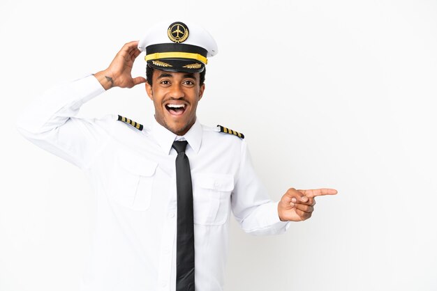 African American Airplane pilot over isolated white background surprised and pointing finger to the side