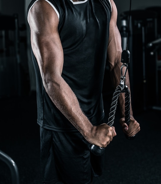 African American athlete training with triceps rope.