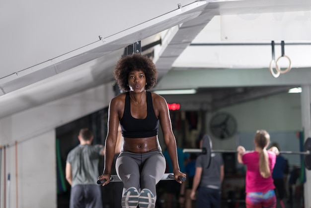 african american athlete woman workout out arms on dips horizontal parallel bars Exercise training triceps and biceps doing push ups