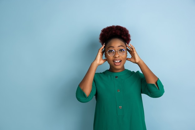 African-american beautiful woman's portrait on blue studio background