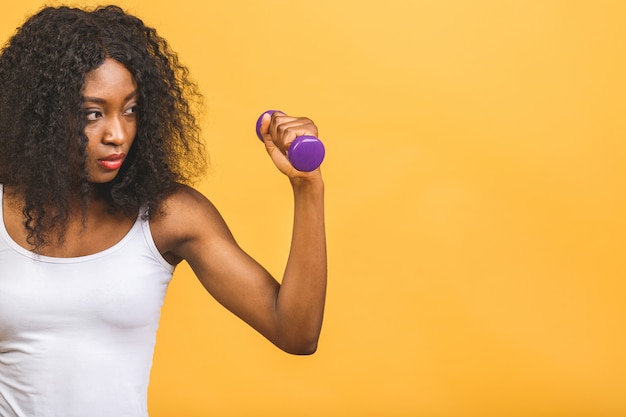 African american black young woman exercising her muscle with dumbbells