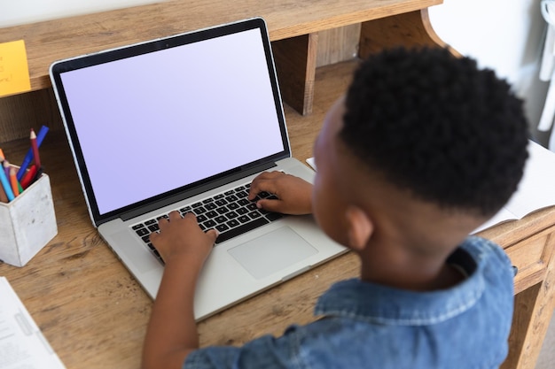 African american boy having video call using laptop during class at home