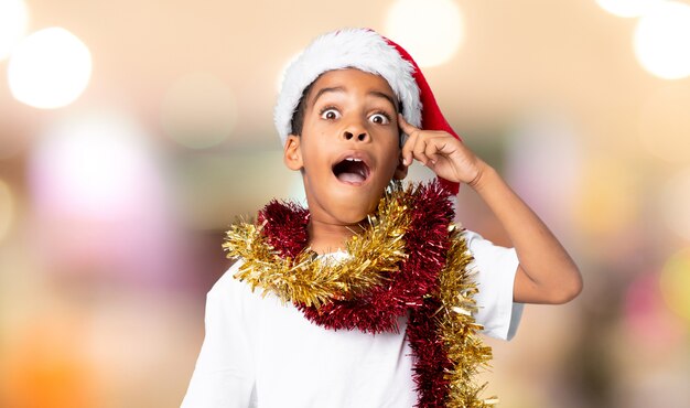 African American boy with christmas hat intending to realizes the solution over blurred background